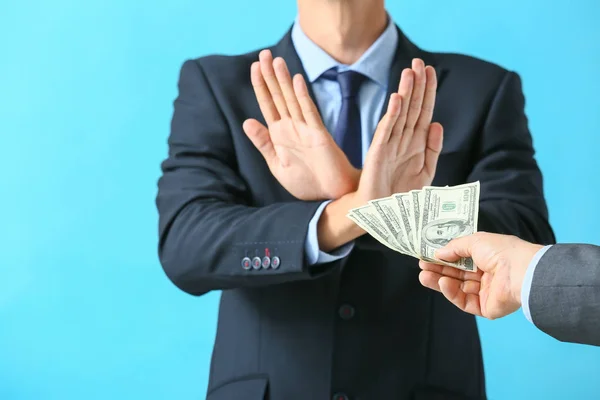 Businessman refusing to take bribe against color background — Stock Photo, Image