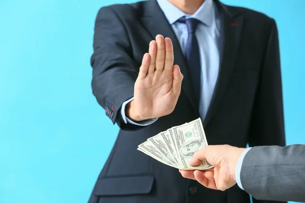 Businessman refusing to take bribe against color background — Stock Photo, Image