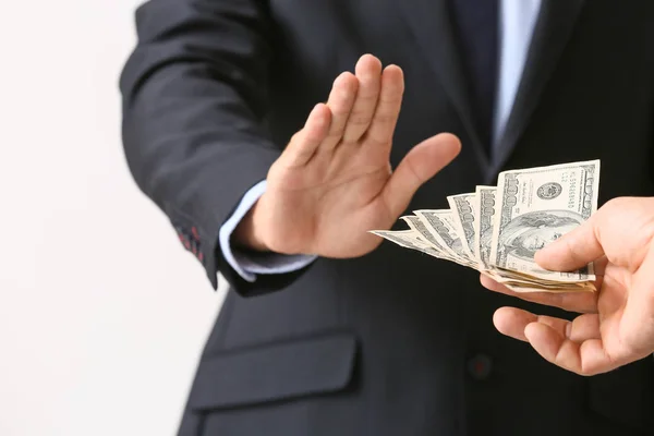 Businessman refusing to take bribe against light background, closeup — Stock Photo, Image