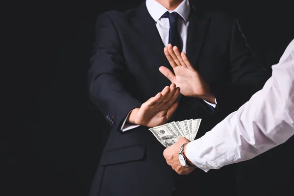 Businessman refusing to take bribe against dark background — Stock Photo, Image