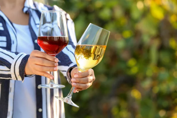 Mujer con copas de sabroso vino en viñedo — Foto de Stock