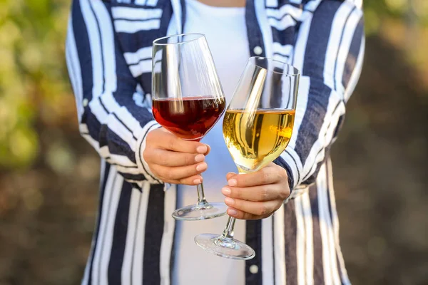 Mujer con copas de sabroso vino en viñedo — Foto de Stock