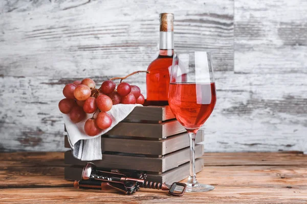 Композиция с вкусным вином и виноградом на столе — стоковое фото
