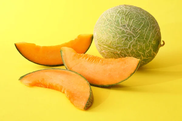 Söt mogen melon och skivor på färg bakgrund — Stockfoto