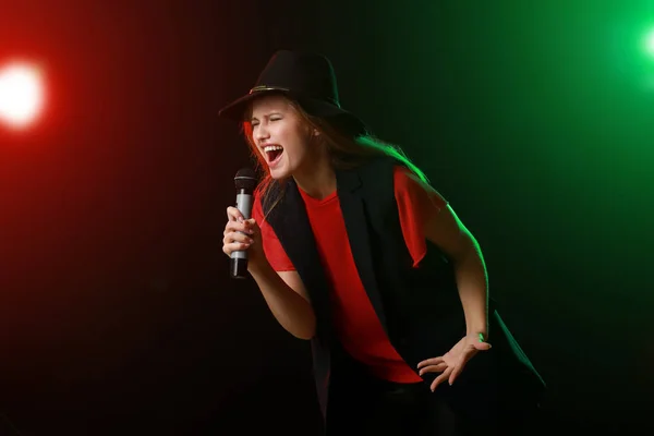 Linda jovem cantora com microfone no palco — Fotografia de Stock