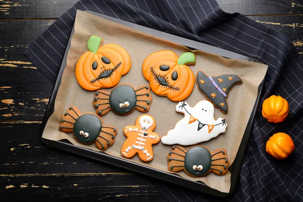 Bandeja de cozimento com biscoitos criativos de Halloween no fundo de madeira — Fotografia de Stock