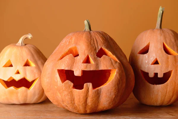 Calabazas de Halloween sobre mesa de madera contra fondo de color —  Fotos de Stock