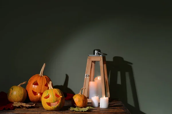 Geschnitzte Kürbisse für Halloween und Kerzen auf Holztisch — Stockfoto