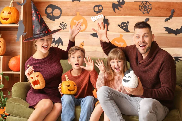 Divertida familia sentada en la habitación decorada para Halloween —  Fotos de Stock