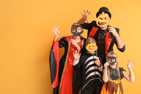 Familie in Halloween kostuums op kleur achtergrond — Stockfoto