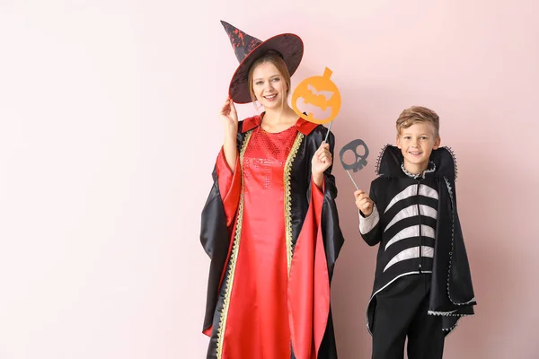 Mãe com filho pequeno em trajes de Halloween no fundo de cor — Fotografia de Stock