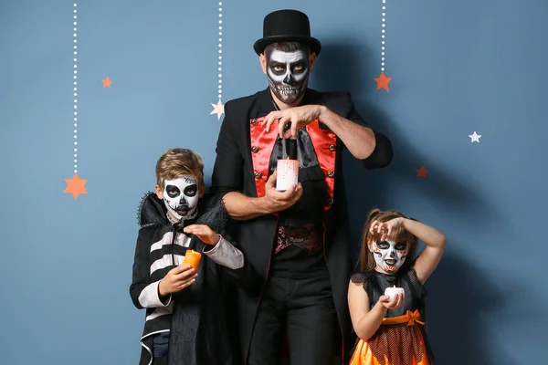 Father with children in Halloween costumes and with candles on color background — Stock Photo, Image