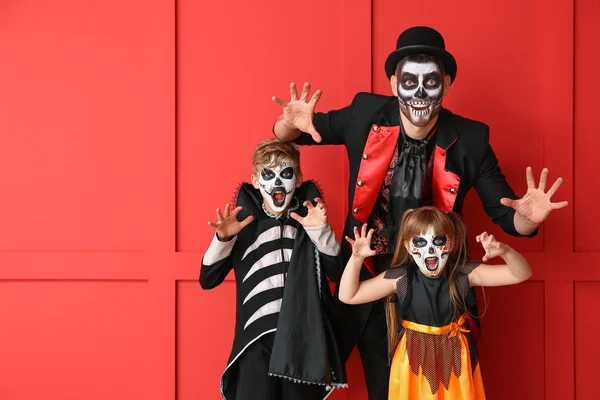 Cadılar Bayramı kostümlü, renkli arka planda çocukları olan baba. — Stok fotoğraf
