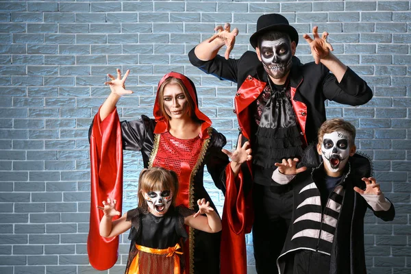 Família em trajes de Halloween no fundo de tijolo — Fotografia de Stock