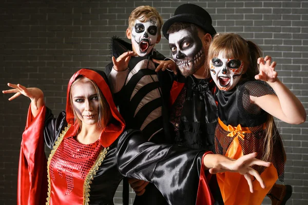 Família em trajes de Halloween no fundo de tijolo — Fotografia de Stock