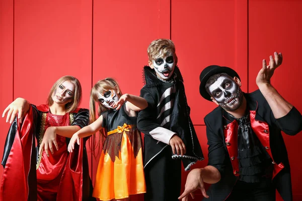 Family in Halloween costumes on color background — ストック写真