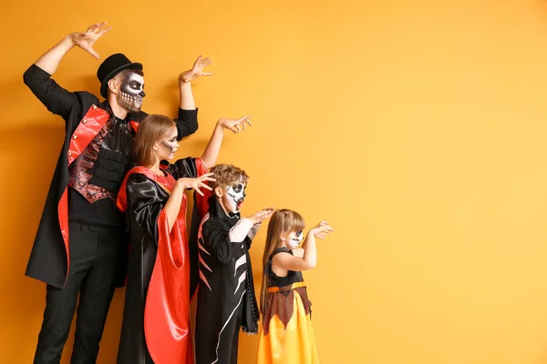 Familie in Halloween kostuums op kleur achtergrond — Stockfoto