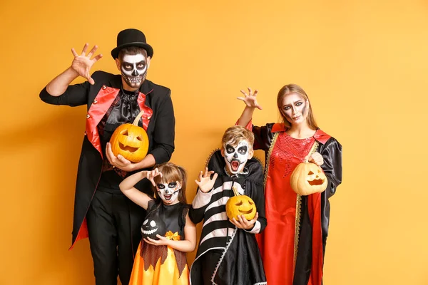 Familia en disfraces de Halloween y con calabazas sobre fondo de color —  Fotos de Stock