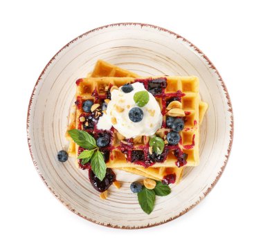 Beyaz arka planda lezzetli waffle, dondurma ve yaban mersini tabağı