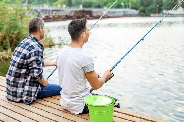 Joven y su padre pescando en el río — Foto de Stock