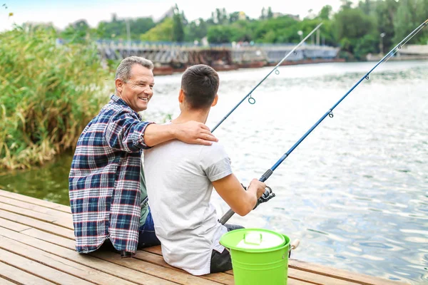 Joven y su padre pescando en el río — Foto de Stock