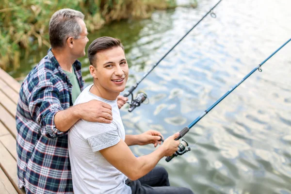 Joven y su padre pescando en el río — Foto de Stock