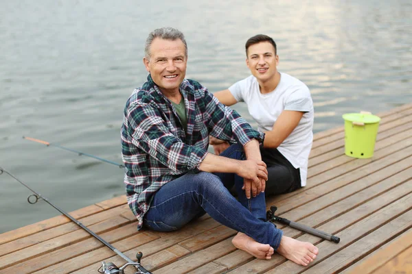 Joven y su padre pescando en el río — Foto de Stock