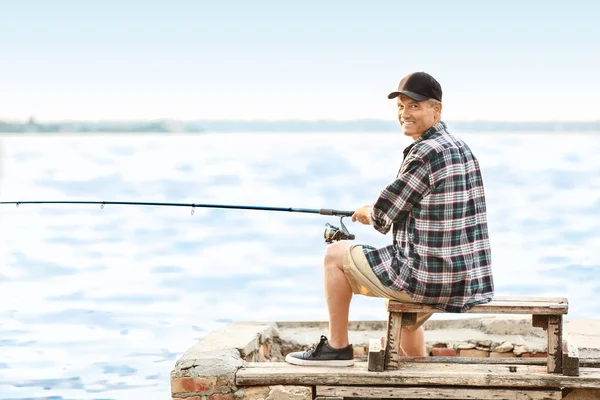 Hombre maduro pescando en el río — Foto de Stock