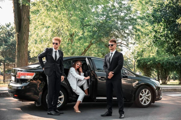 Giovane celebrità uscire dalla macchina circondata da guardie del corpo — Foto Stock