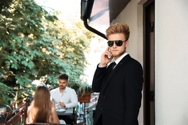 Bodyguard protecting young couple in cafe — ストック写真