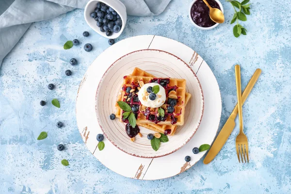 Plate with tasty waffles, ice cream and blueberries on color background — Stock Photo, Image