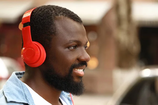 Handsome African-American man listening to music outdoors — Stock Photo, Image