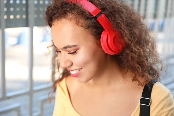 Beautiful African-American woman listening to music outdoors — Stock Photo, Image