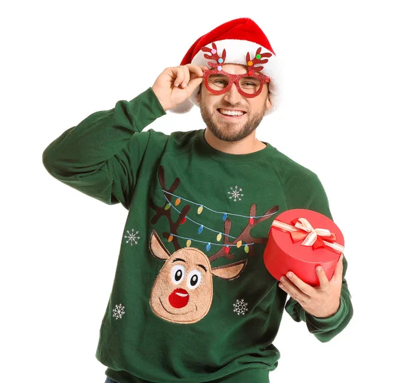 Lustiger Mann in Weihnachtspullover, Weihnachtsmütze und mit Geschenk auf weißem Hintergrund — Stockfoto