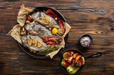 Ahşap arka planda sebzeli dorado balığı.