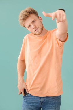 Renkli arka planda izleyiciye bakan genç bir adamın portresi