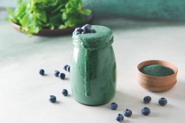 Masada bir kavanoz sağlıklı spirulina içeceği var.