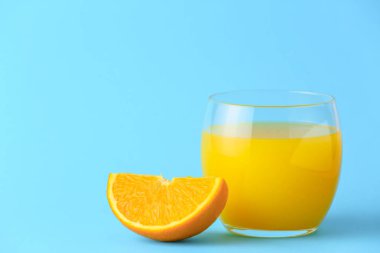 Arka planda bir bardak taze portakal suyu