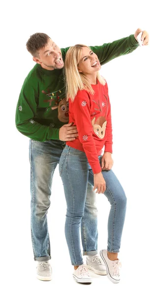 Happy couple in Christmas sweaters taking selfie on white background — Stock Photo, Image