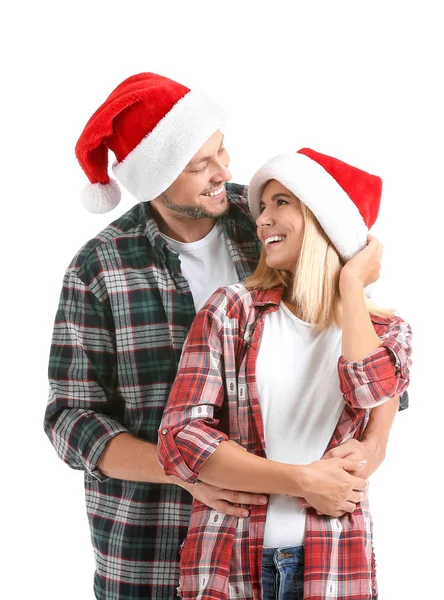 Casal feliz em chapéus de Santa no fundo branco — Fotografia de Stock