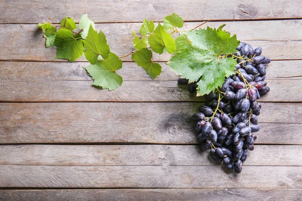 Tasty sweet grapes on wooden table — Stock Photo, Image