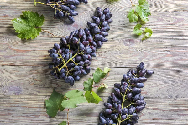 Tasty sweet grapes on wooden table — Stock Photo, Image