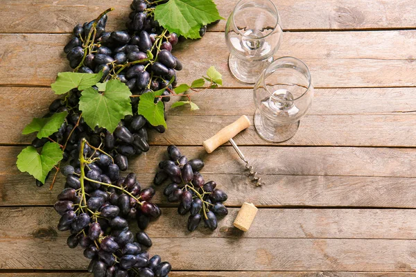 Sweet grapes with wineglasses corkscrew on wooden table — Stock Photo, Image