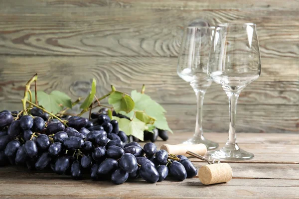 Sweet grapes with wineglasses corkscrew on wooden table — Stock Photo, Image