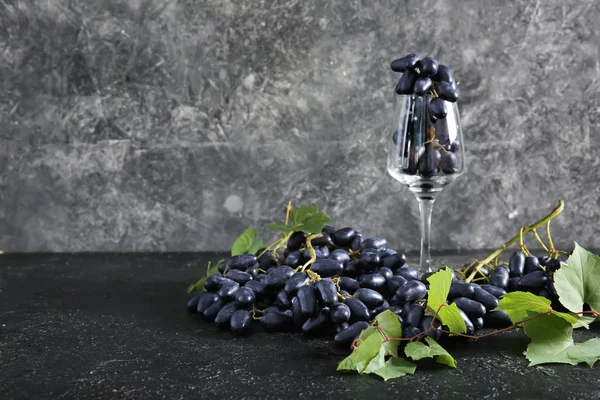 Sweet grapes with wineglass on grey background — Stock Photo, Image