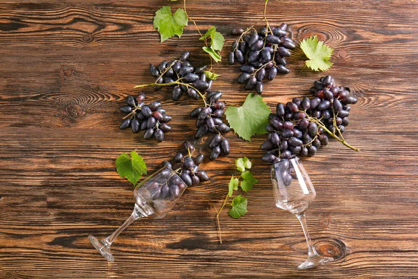 Сладкий виноград с бокалами на деревянном столе — стоковое фото