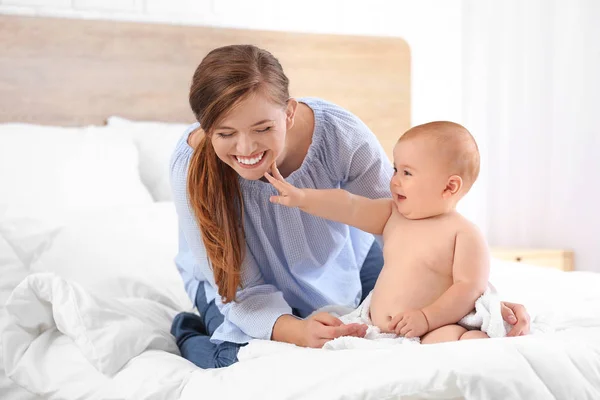 Vrouw en haar schattige kleine baby na het baden in de slaapkamer — Stockfoto