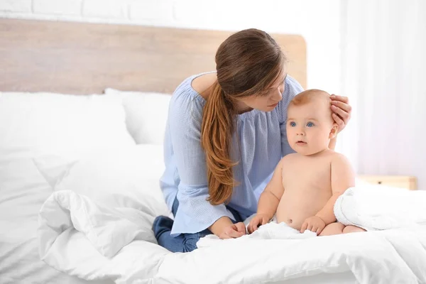 Vrouw en haar schattige kleine baby na het baden in de slaapkamer — Stockfoto