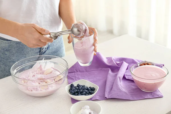 부엌에 있는 유리에 맛있는 블루베리 아이스크림을 넣는 여자 — 스톡 사진