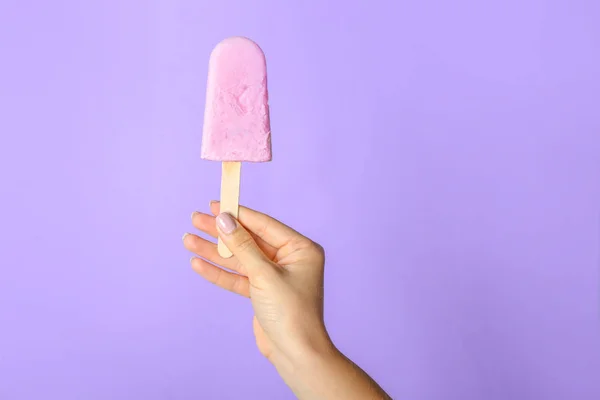 색 배경에 맛있는 블루베리 아이스크림을 곁들인 암컷 손 — 스톡 사진